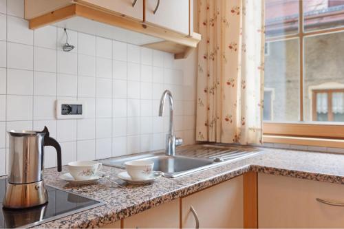 a kitchen with a sink and two cups on a counter at Appartamenti Boé 1 in Livinallongo del Col di Lana