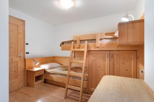 a room with a bunk bed and a desk at Appartamenti Boé 1 in Livinallongo del Col di Lana