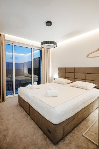 a bedroom with a large bed and a large window at Villa The One Mostar with Heated Pool & Jacuzzi in Mostar