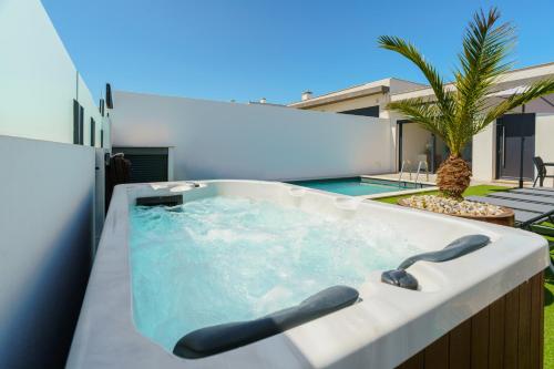 a jacuzzi tub on the balcony of a house at Villa Emilio with private pool in Mariquiteira