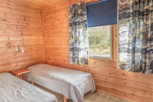a log cabin with two beds and a window at Jehkas Huoneisto B in Kilpisjärvi