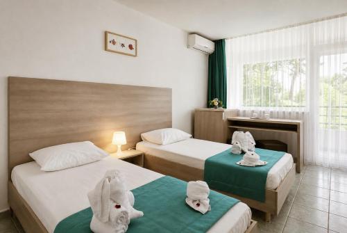 a hotel room with two beds with towels on them at Hotel Favorit in Venus