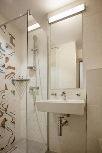 a white bathroom with a sink and a shower at Hotel Favorit in Venus
