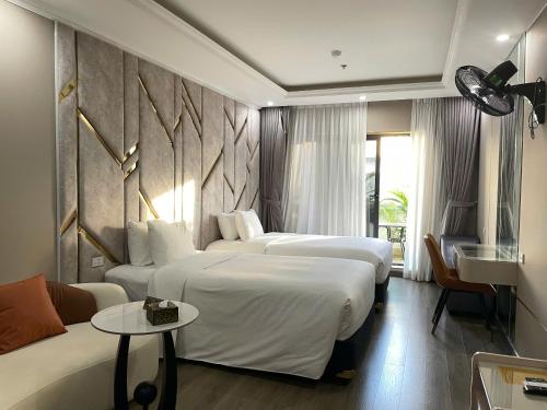 a hotel room with two beds and a couch at Lavie Hotel in Hanoi