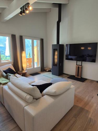 a living room with a white couch and a flat screen tv at ABO - Boutique Apartment - Chalet Horst in Grindelwald
