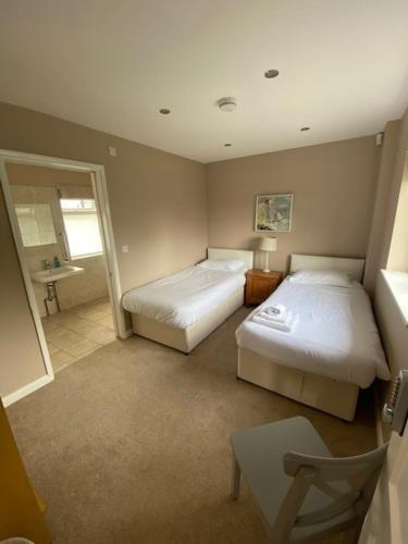 a room with two beds and a bathroom with a mirror at Florence House Bed & Breakfast in Seaford