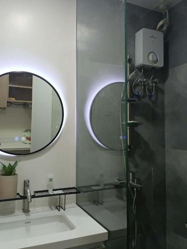 a bathroom with a shower and a sink and a mirror at Sanctuary 5125 by Primeworld District in Agus