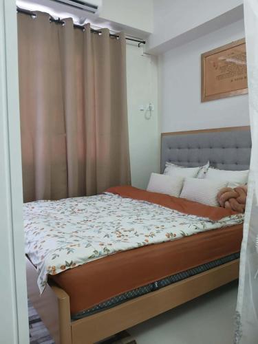 a bedroom with a bed and a curtain at Sanctuary 5125 by Primeworld District in Agus
