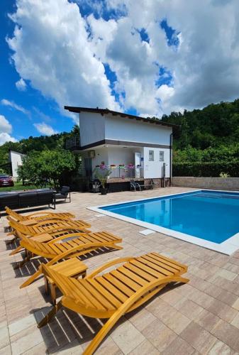 a group of lounge chairs next to a swimming pool at Vikendica na Sani Datea in Sanski most