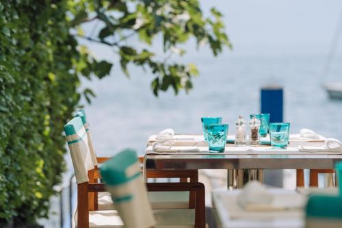 a table with blue glasses on top of it at Hotel Eden Roc Marina in Ascona