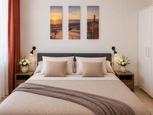 a bedroom with a large bed with four paintings on the wall at Perello Old Town in Split