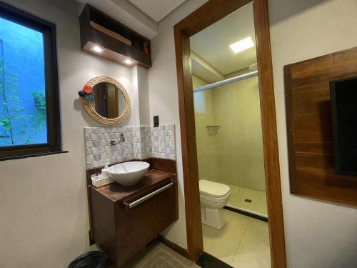 a bathroom with a sink and a toilet and a mirror at Hospedaria de Maria in Salvador