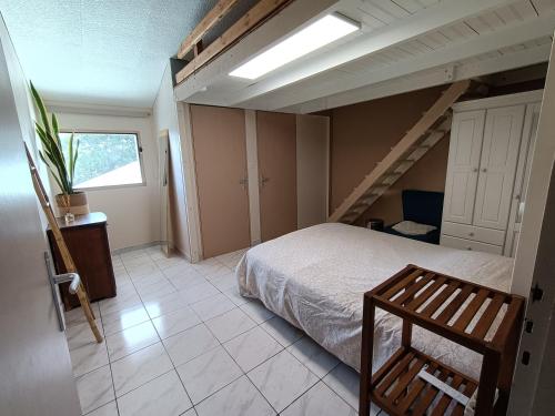 a bedroom with a bed and a stair case at Chambre cosy in Saint-Paul