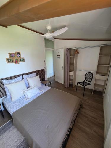 a bedroom with a bed and a ceiling fan at Escale Terre Rouge in Saint-André