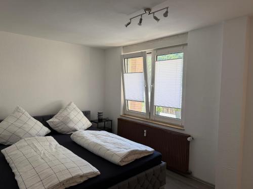 a bedroom with a bed and two windows at Ferienwohnung Auszeit in Vöhl