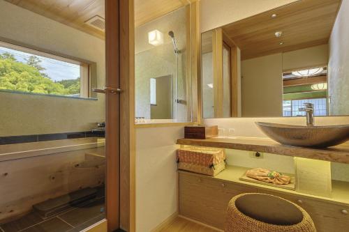 a bathroom with a sink and a mirror at Kotonoyado Musashino in Nara