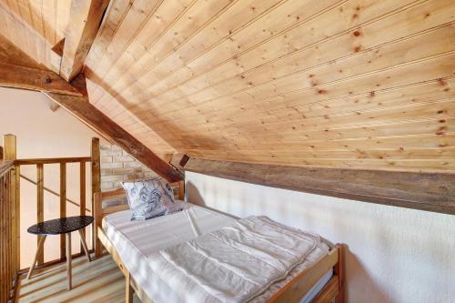 a bed in a room with a wooden ceiling at Gite xl proche Grottes Lascaux in Fossemagne
