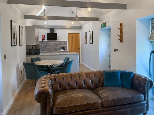 a living room with a brown couch and a table at The Barn - Uk50912 in Wansford