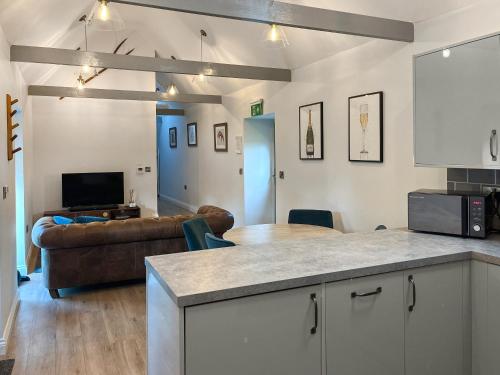 a kitchen and living room with a couch and a table at The Barn - Uk50912 in Wansford