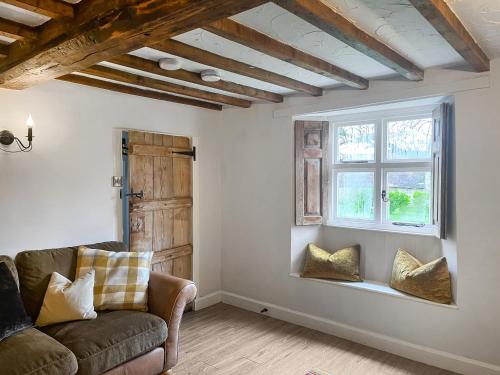 a living room with a couch and a window at The Farmhouse - Uk50909 in Thornhaugh
