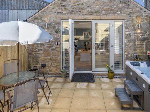 a patio with a table and an umbrella at The Old Byre in Edmondbyers
