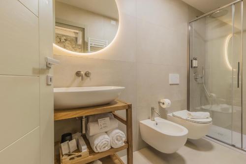 a bathroom with a sink and a toilet and a mirror at La Corte del Lario - Contrada Vecchia in Varenna