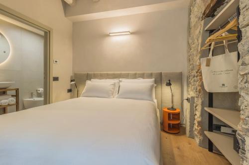 a bedroom with a large white bed in a room at La Corte del Lario - Contrada Vecchia in Varenna