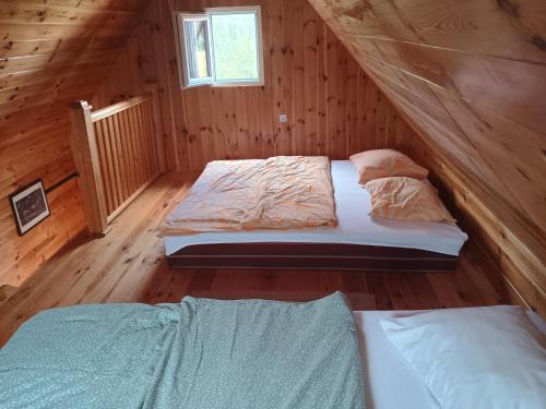 a bedroom with two beds in a wooden cabin at Under Milky Way in Podgora