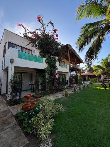 a house with a green yard with a building at Casa Gili Moitas in Praia de Moitas
