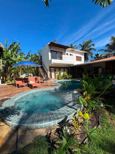 a swimming pool in front of a house at Casa Gili Moitas in Praia de Moitas