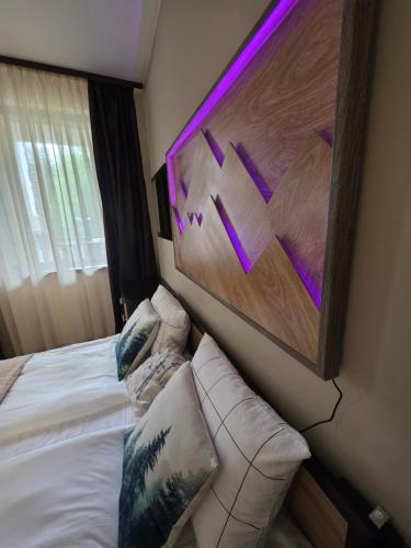 a hotel room with a bed with a painting on the wall at Borovets Gardens Studio Raya in Borovets
