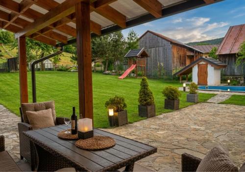 a patio with a table and chairs and a barn at Rusínsky Dvor s privátnym Wellness in Malý Lipník