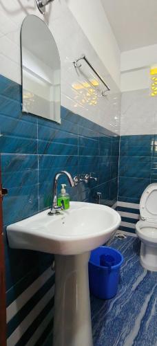 a bathroom with a sink and a toilet at The Jhandi Nest in Gorubathān