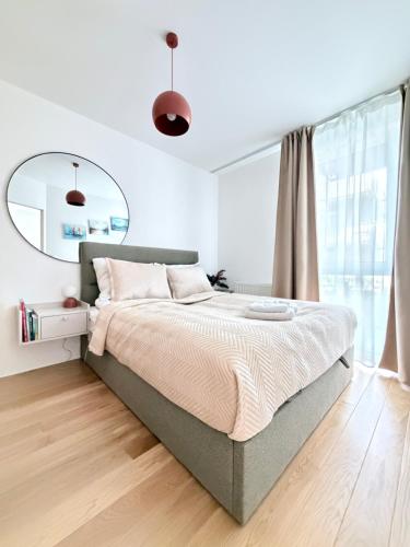 a bedroom with a large bed and a mirror at Len Apartments One Gdańsk Sobieszewo Baltic Line blisko morza na Wyspie Sobieszewskiej dla rodzin przyjazny zwierzętom z tarasem in Gdańsk