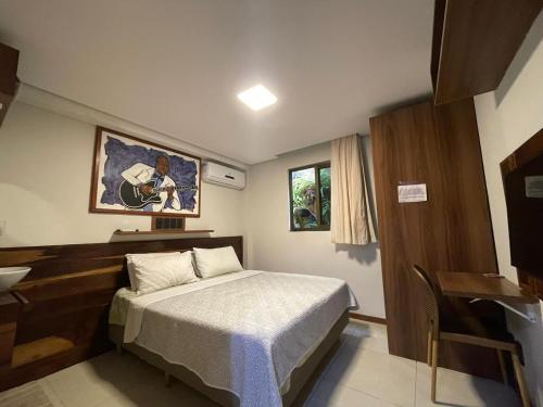a bedroom with a bed and a sink and a desk at Hospedaria de Maria in Salvador