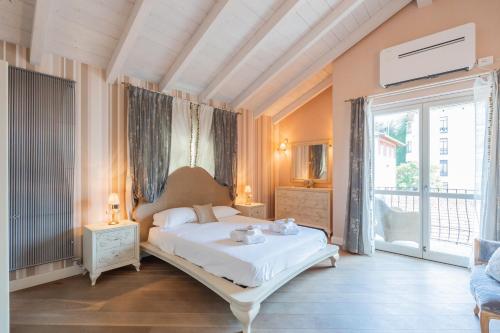 a bedroom with a white bed and a large window at Luxury Villa in Tremezzo con piscina in Tremezzo