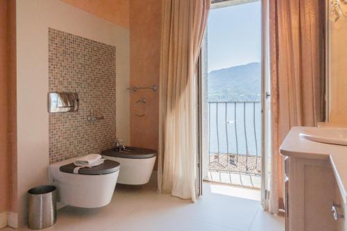 a bathroom with a toilet and a large window at Luxury Villa in Tremezzo con piscina in Tremezzo