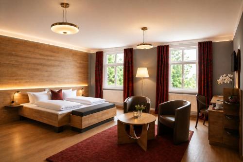 a hotel room with a bed and a table and chairs at Kulturhotel Kaiserhof in Bad Liebenstein
