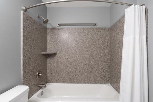 a bathroom with a tub and a shower curtain at La Casa Inn Albany Near Tifton GA I 75 in Albany