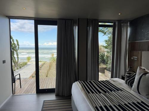 a bedroom with a bed and a view of the ocean at The Ocean View Guest House in Wilderness