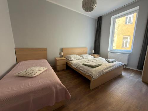 a bedroom with two beds and a window at Apartmány Mary in Litoměřice