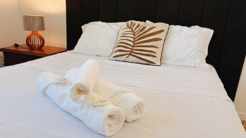 a white bed with towels on top of it at Suíte no Centro de Caxambu - Poucos metros do Parque in Caxambu
