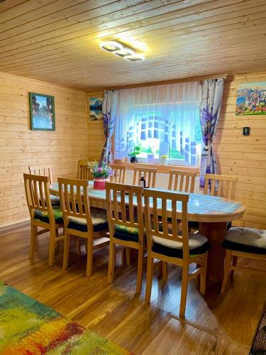 a dining room with a wooden table and chairs at Mounty vendégház in Borzont