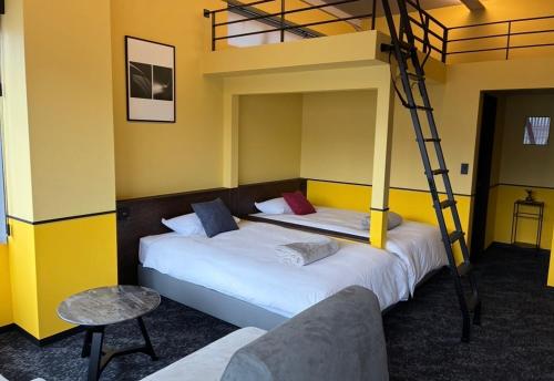 two beds in a room with a bunk bed at TAP Inn MIURA in Miura
