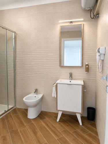 a bathroom with a toilet and a sink and a mirror at L'Ariana Resort, Glamping in Rinella