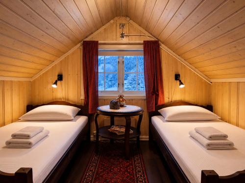 two beds in a small room with a window at Charming Cabin Near Hallingskarvet Ski Center, Cozy and Inviting! in Skoro