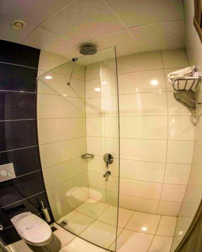 a bathroom with a glass shower with a toilet at Ceti̇n Presti̇ge Resort in Erdek