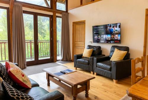 a living room with a couch and a table at Top Floor Chalet Apartment in Saint-Jean-d'Aulps, Balcony in Saint-Jean-d'Aulps