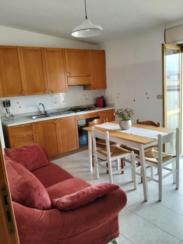 a living room with a couch and a table and a kitchen at Una Terrazza sul mare in San Ferdinando