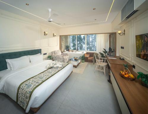 a bedroom with a bed and a desk and a kitchen at 1924 Clock House Munnar in Munnar